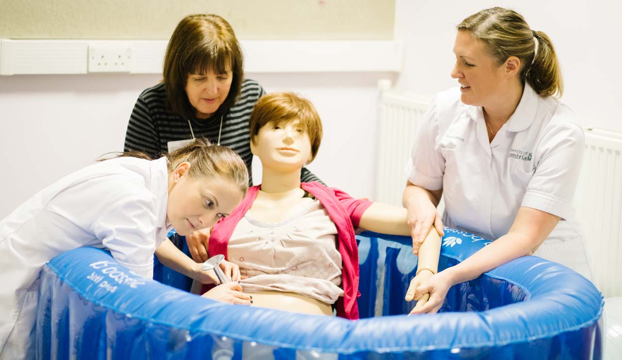 Midwifery students learning how to use the birthing pool in the Midwifery Suite.