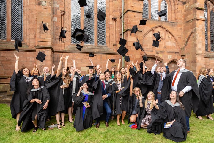 Graduation July 2019, graduation July 2019, group of students in front of Carlise cathedral throwing their graduation hats into the air