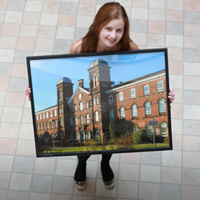 A woman holding a photo of Fusehill Street campus 