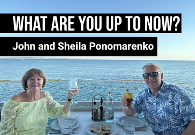 A man and woman enjoying a meal with the sea in the background