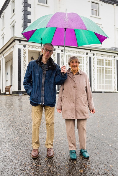 Audrey Wright and her son standing in front of Scale House in the rain