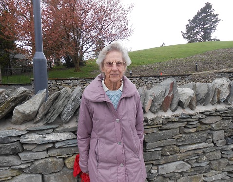 Charlotte Mason alumni stands in front of a dry stone wall