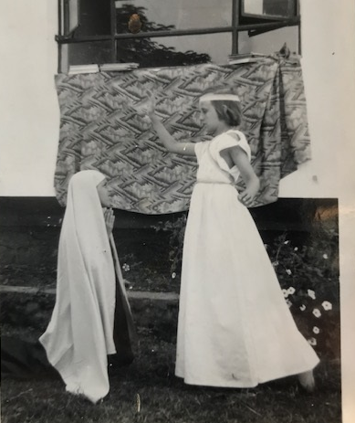 Black and white image from the 1950s showing young girls in white dresses