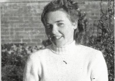 A black and white image of a young woman wearing a white roll neck sweater