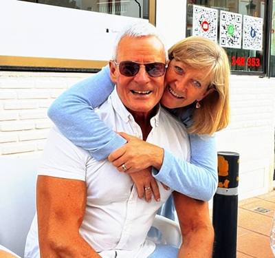 Man with white hair and white shirt and a woman