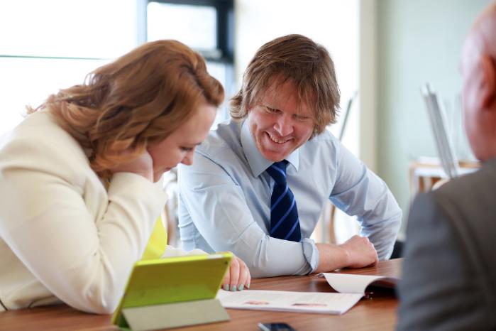 2 mature students studying around a desk.