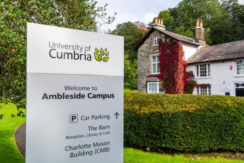 A University of Cumbria branded sign at the entrance of the Ambleside campus.