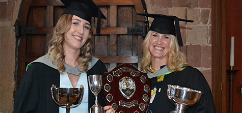 Radiography , 2 female graduates smiling while holding awards