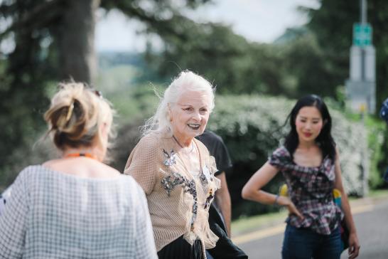 13_reason_VW, An outdoor candid photo of an older, boldly dressed lady, accompanied by two other females who are out of focus.