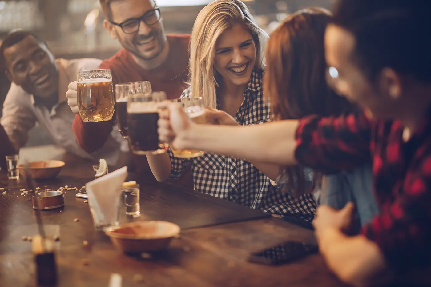 hosting resized, A group of people toasting with drinkings at a table., 