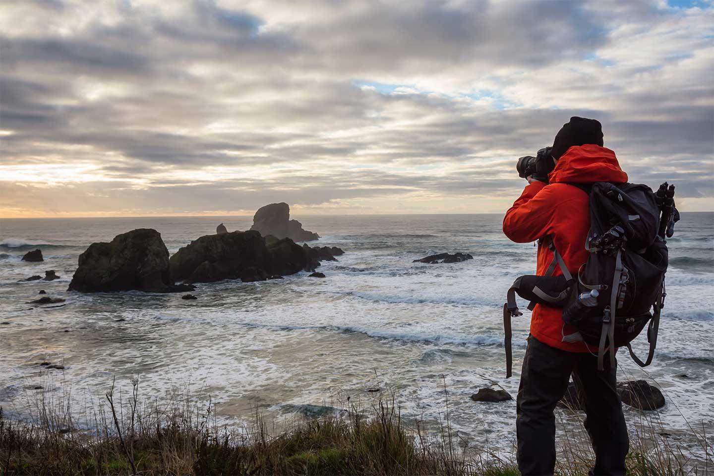 A man photographing the sea, A man taking photographs of the sea at twilight.