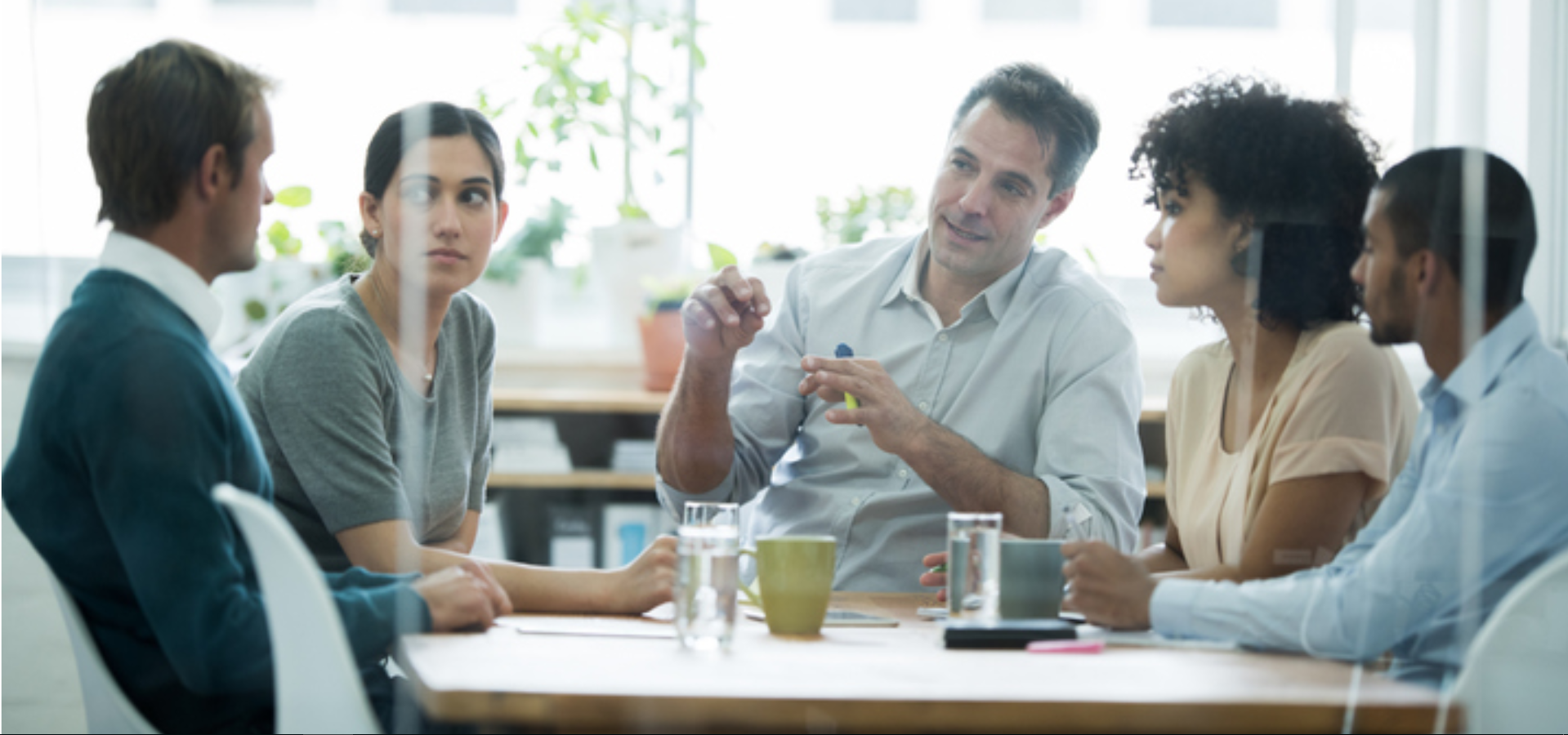A muliticultural group of 3 men and two women discussing something. Image provided by Stephen Mullen