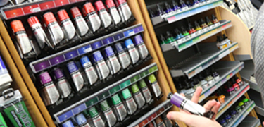 A person looking at a selection of paints