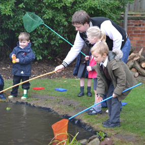 male with children fishing in a pond