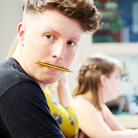 male with pencil in mouth