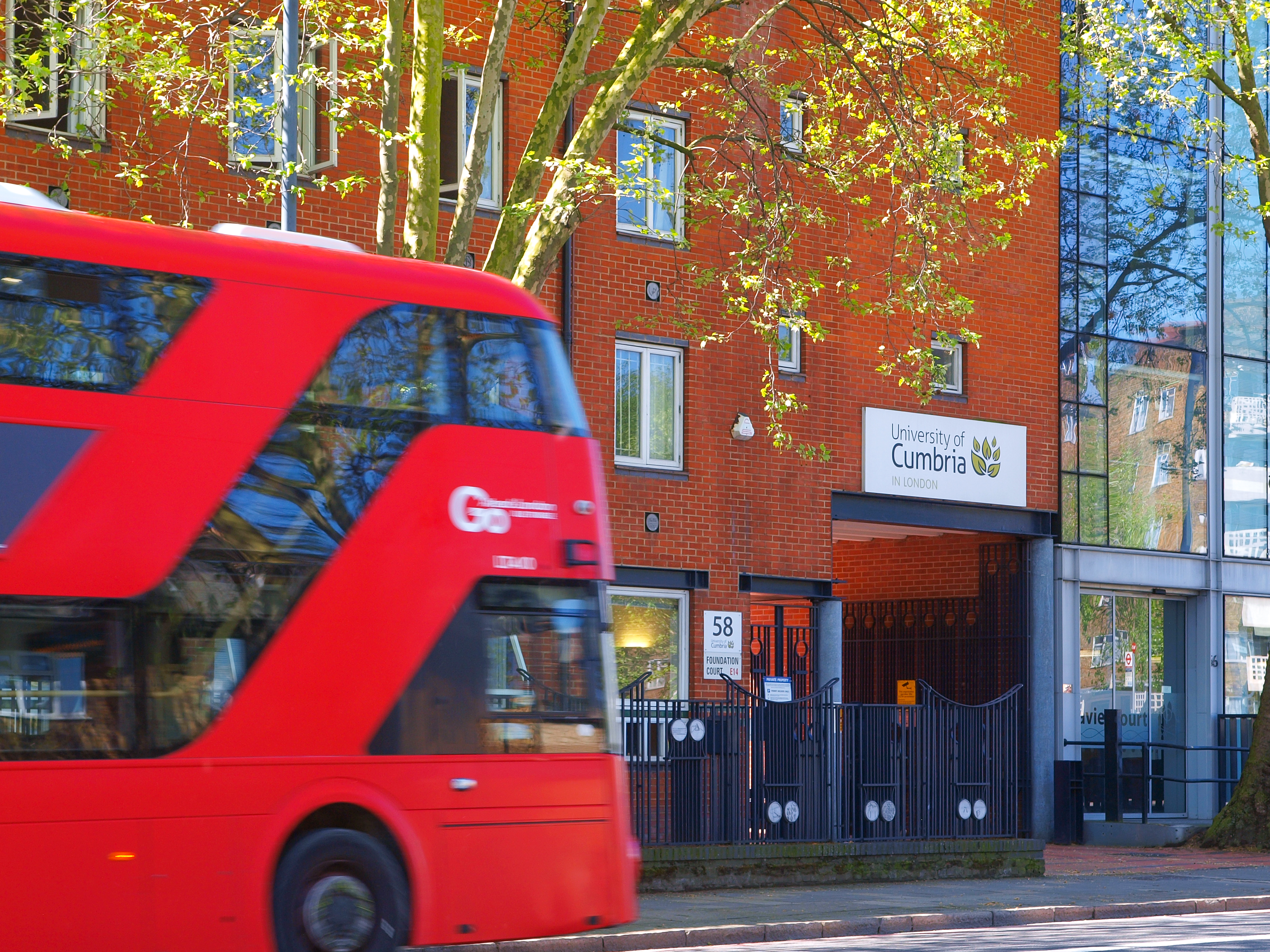 University of Cumbria's London campus in sharp focus as a red bus drive past in 