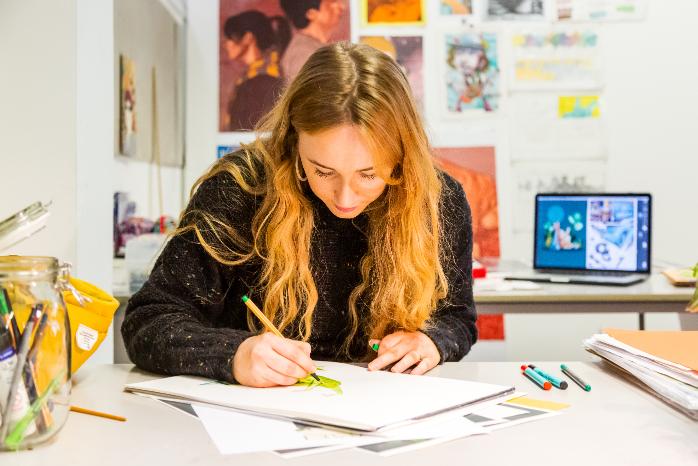 A student completes an illustration project.