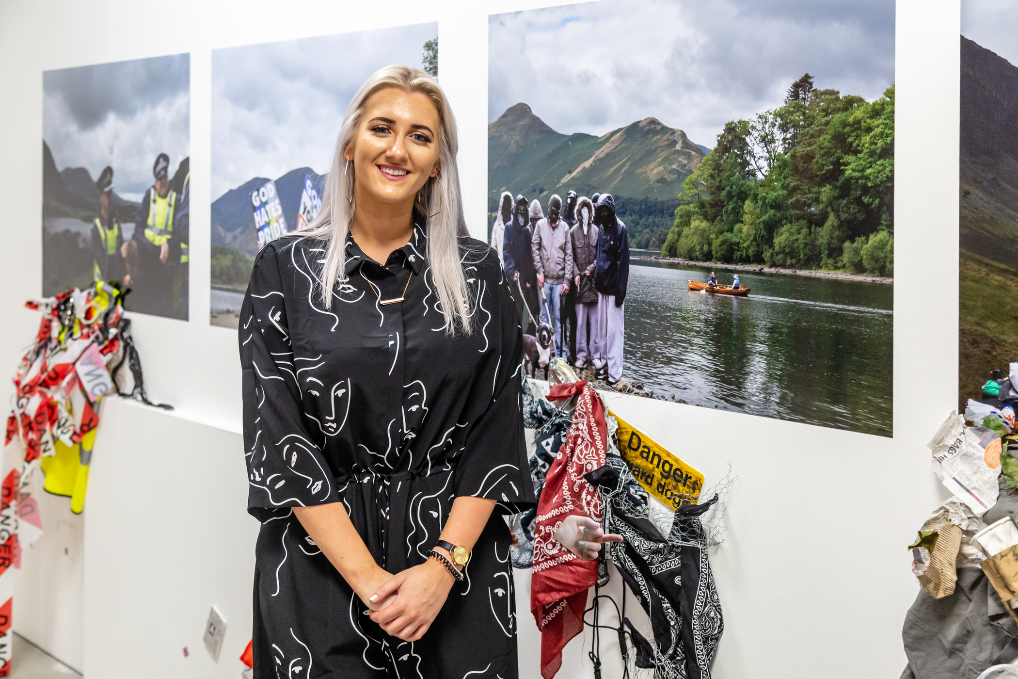 A student stands in front of their landscape photography.
