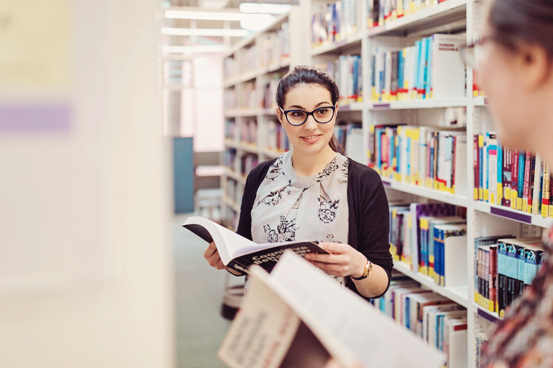 Students looking at books in the library.