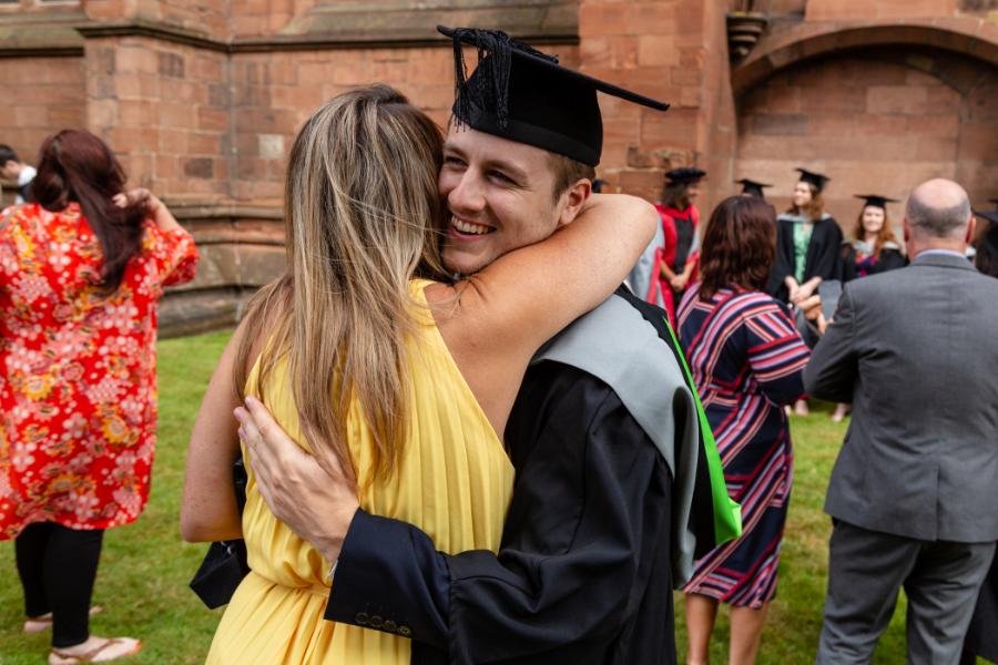 Graduate hugging a family member.