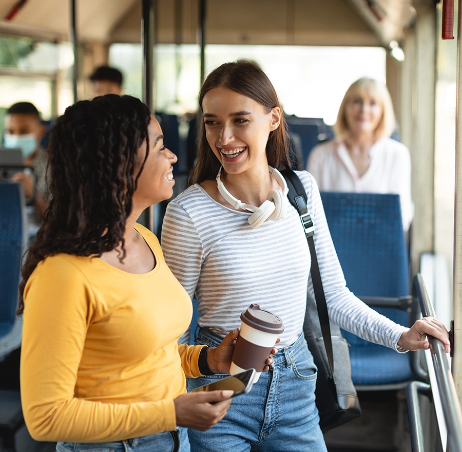 Smiling women standing in bus and talking
