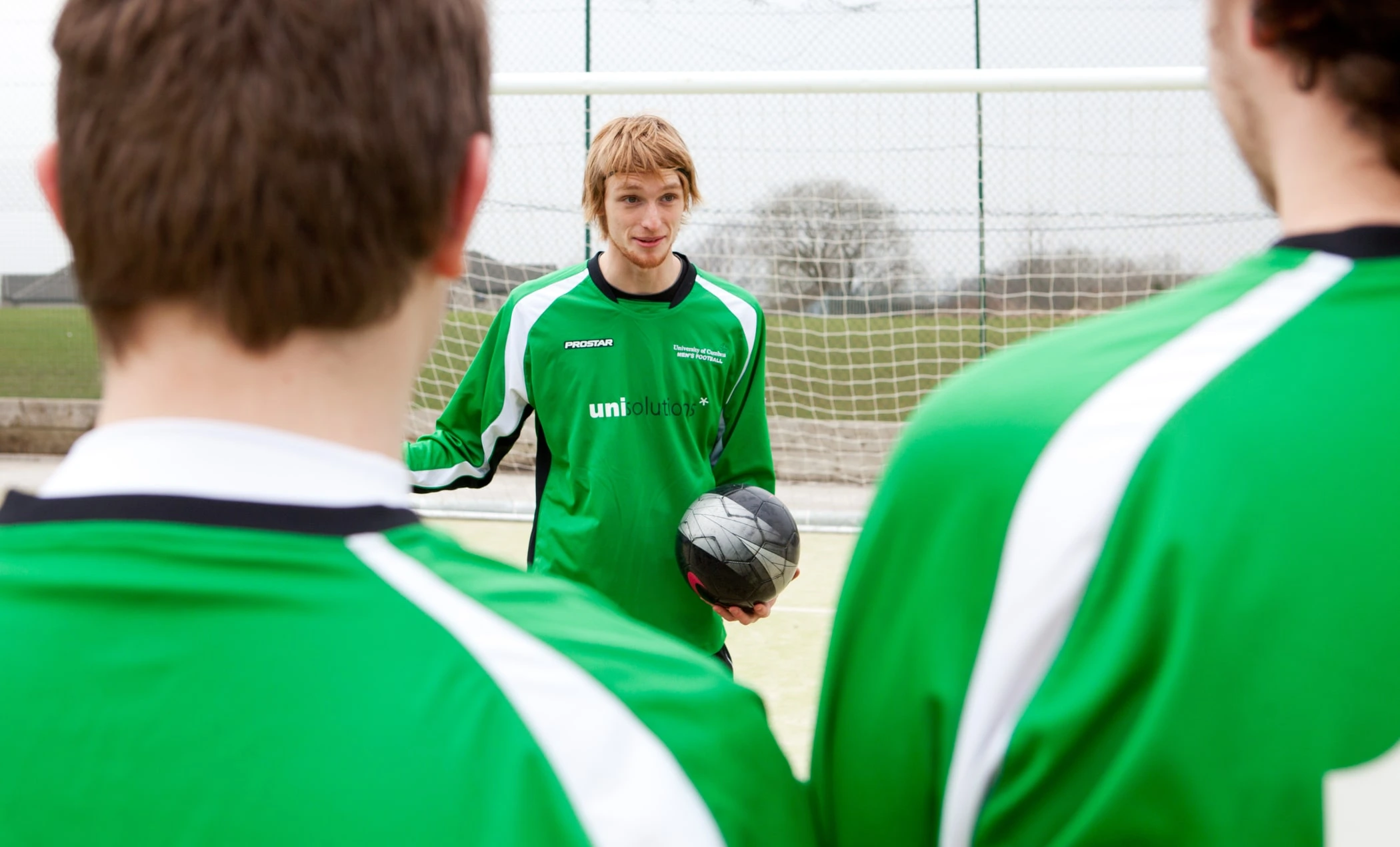 A football team talking on the field.