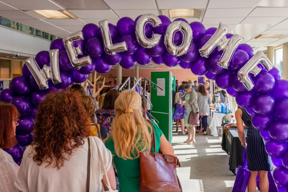 A large balloon banner reads Welcome.