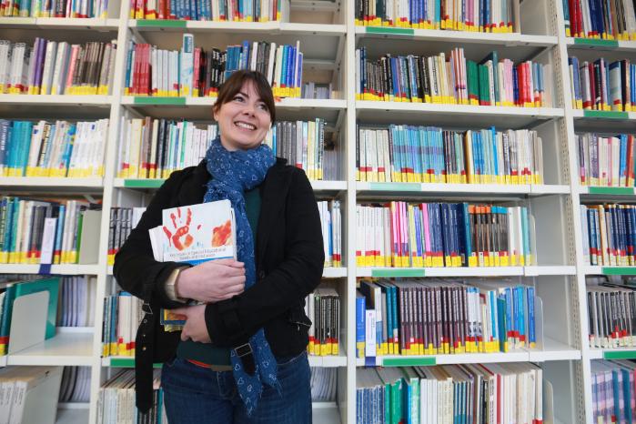Student stood in a library with books