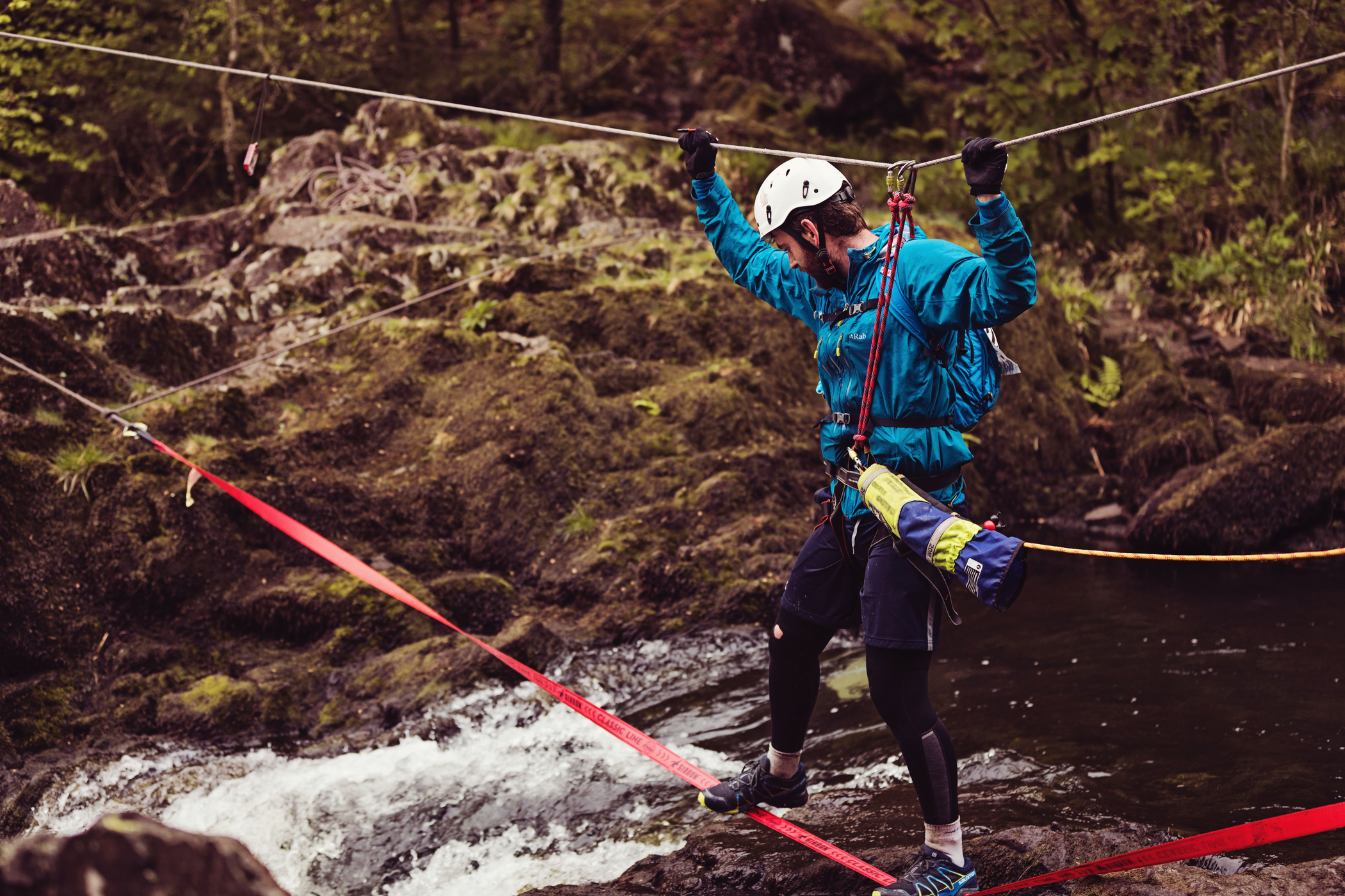A student high-roping across a river. A student high-roping across a river.
