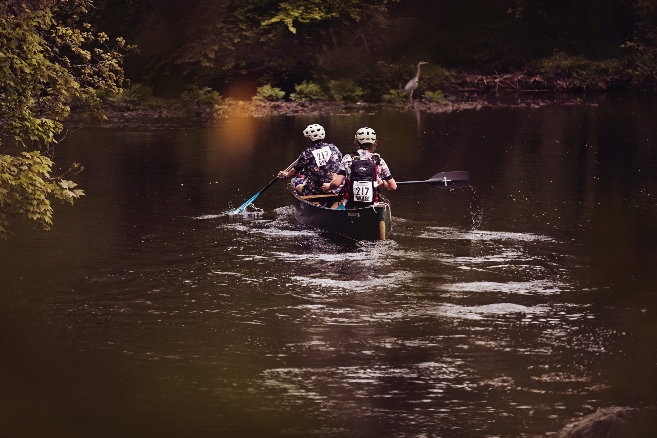 Two students canoe across a river. Two students canoe across a river.