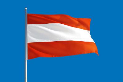 Austria flag with the city of Salzburg in the background.