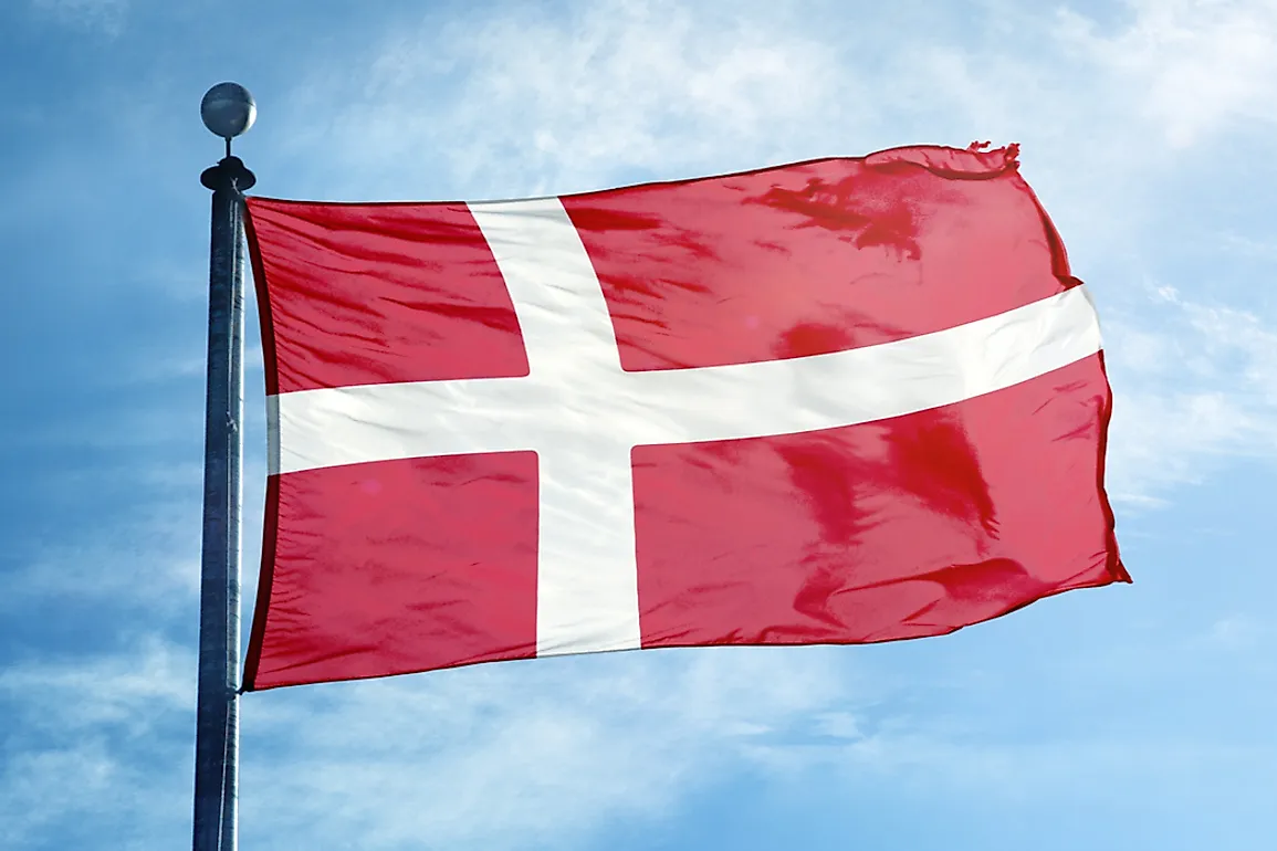 The flag of Denmark at the top of a flag pole.