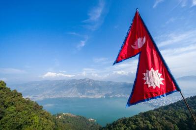 Flag of Nepal in front of a mountain.