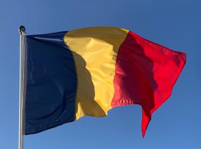 The Romanian flag on a flagpole.