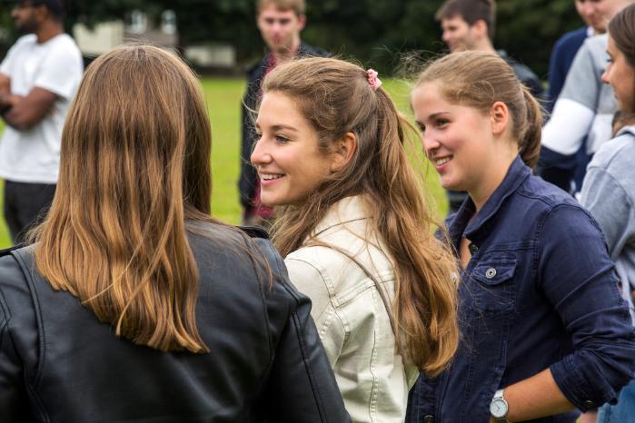 International students stand in a group smiling.