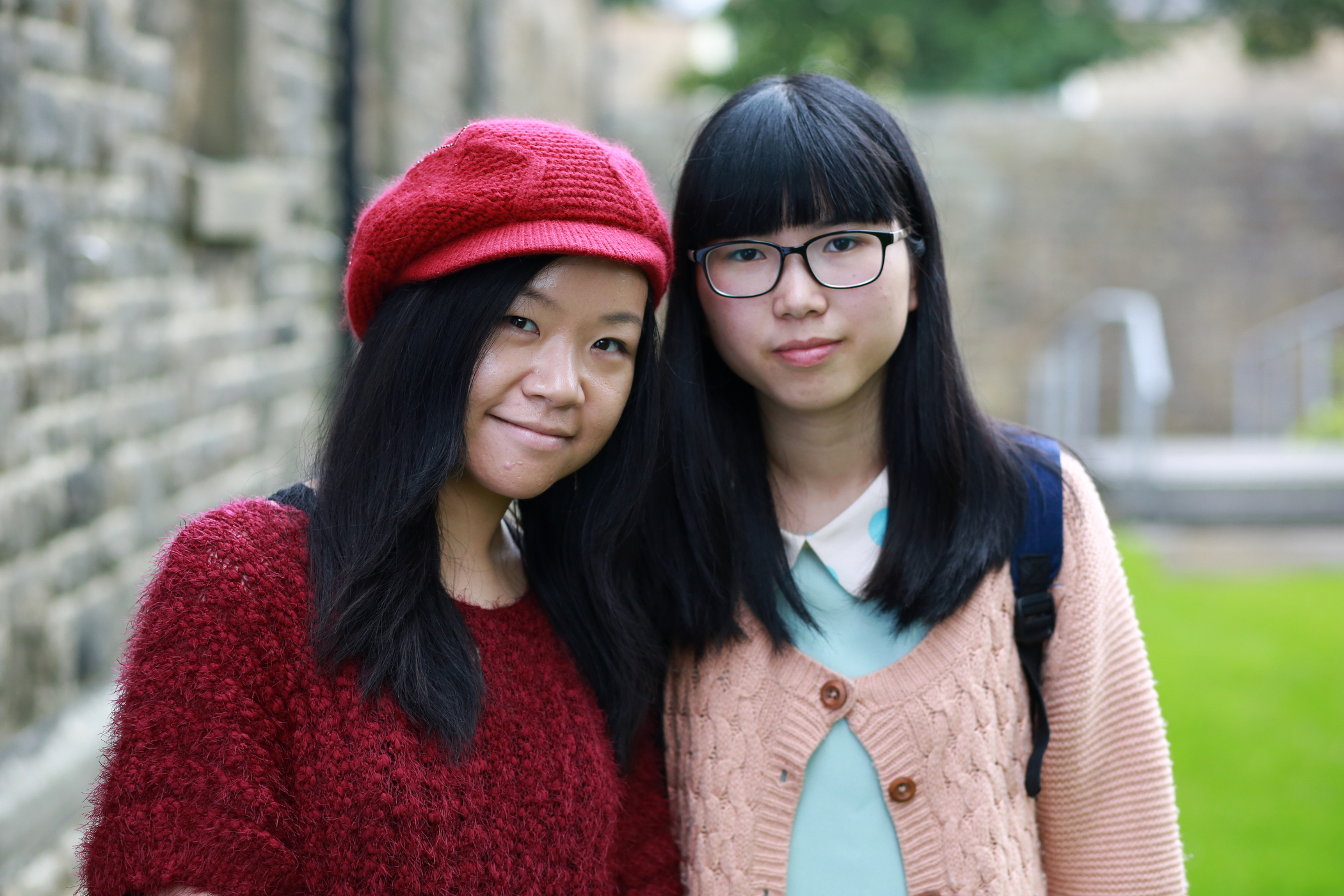Two international students smile at the camera.